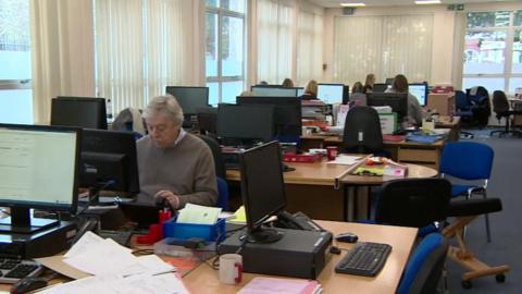 A team of volunteers at Citizens Advice Exeter seated at desks while working at  computers