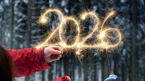 Hands writing 2026 with sparklers