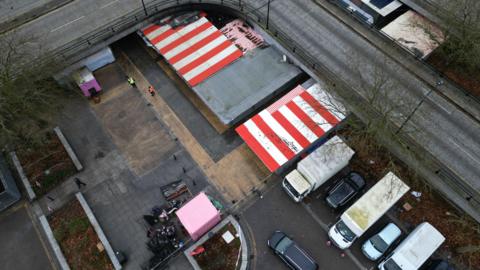 An aerial view of Milton Keynes Market. Some charred debris and stall roofs can be seen.