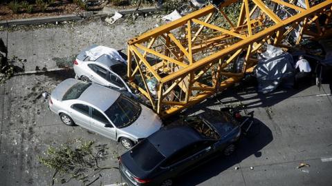 A police officer inspects one of the cars crushed by part of a construction crane in Seattle, Washington, April 27, 2019