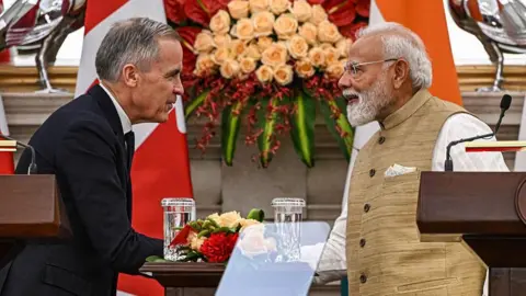 Narendra Modi, India's prime minister, right, shakes hands with Mark Carney, Canada's prime minister, during a news conference at Hyderabad House in New Delhi, India, on Monday, March 2, 2026. 