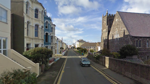 Waterloo Road, a residential street, with a stone Church on the right of the road.