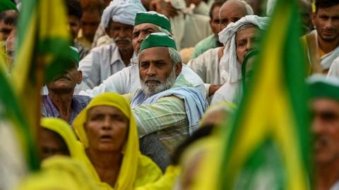 Farmers and supporters representing various unions listen to a speaker as they attend a Mahapanchayat or a huge gathering in Muzaffarnagar on September 5