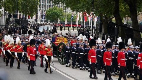 A bearer party lifts the Queen's coffin from Westminster Hall and carries it in procession to the state gun carriage.