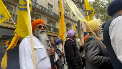 Sikh protestors in London wave yellow flags emblazoned with the word 'Khalistan', the name of an independent Sikh state they are calling for.