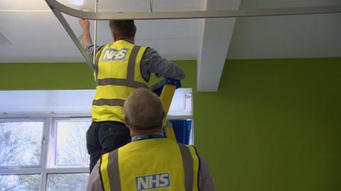 NHS workers looking at a hospital roof