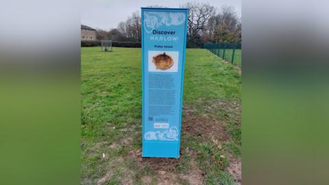 Blue heritage signpost in the grass