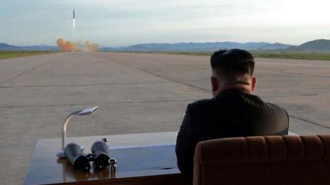 North Korean leader Kim Jong Un watches the launch of a Hwasong-12 missile