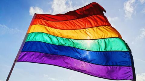 A pride flag blowing in the wind 