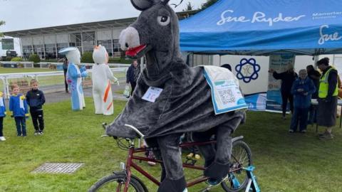 Men on tandem in side panto horse