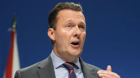 Scottish Conservative leader Russell Findlay in front of a Union Jack flag
