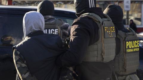 A Federal Agent arrest a man after stopping and questioning him in the street during an Immigration Enforcement Operation in Minneapolis, Minneapolis, MN, U.S., January 14, 2026.