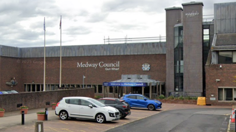 A Google Street image of a brown bricked-building. There are letters on the front which say "Medway Council Gun Wharf" and another sign that says "Welcome to Medway Council".