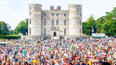 Thousands of people gathering in front of Lulworth Castle in Dorset