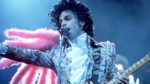 Prince performs live at the Fabulous Forum on February 19, 1985 in Inglewood, California, wearing a silver jacket and pink feather boa