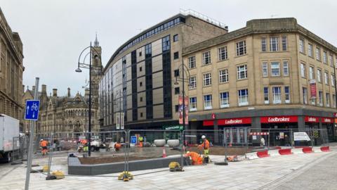 A large building with a number of betting shop fronts on the ground floor