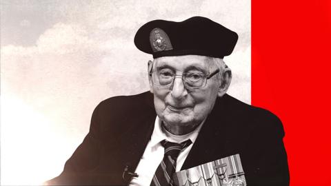 An older man looking directly into the camera. He is wearing a shirt, tie and a jacket which has medals on the front. He is also wearing a beret and glasses.  