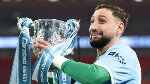 Gianluigi Donnarumma lifting the EFL Cup trophy