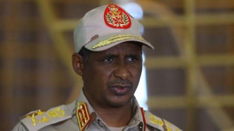 Mohamed Hamdan Dagalo wearing a beige military cap with a round red logo.