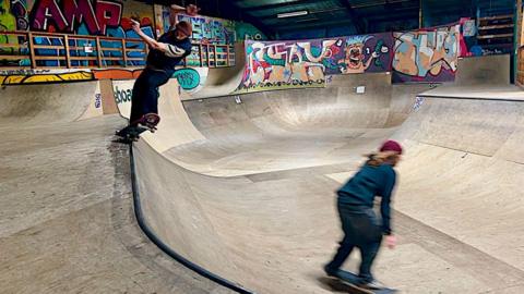 Two skateboarders are shown in action at the skatepark