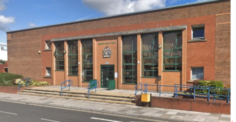 A red-brick court building with steps outside and a crest above the door. 'Magistrates Court' is written on the building.