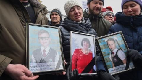 People hold portraits of some of the victims of the fire in Kemerovo. Photo: 27 March 2018