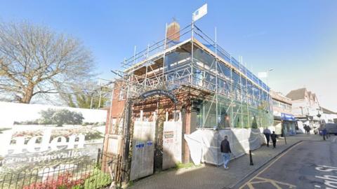 The Feathers pub covered by scaffolding and sheeting