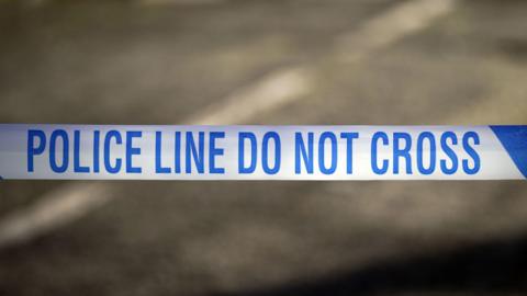 Police tape with blue writing on a white background.