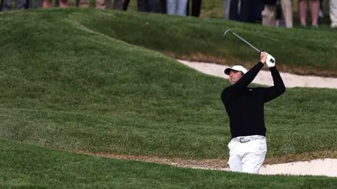 Scottie Scheffler plays out of a bunker