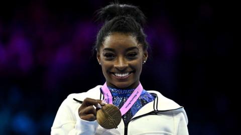 Simon Biles holds her gold medal at the World Gymnastics Championships