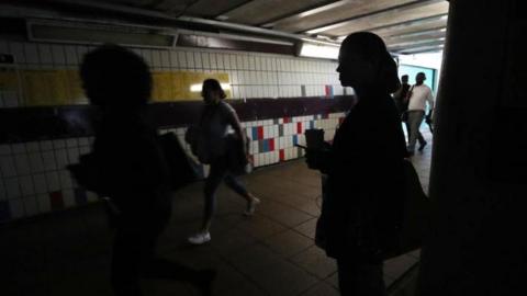 People walking in complete darkness at Clapham Junction station in London