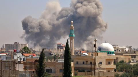 Smoke rises from the rebel-held town of Nawa, north of Deraa, Syria, during air strikes by pro-government forces (27 June 2018)