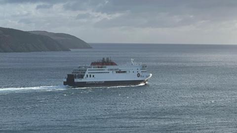 The Manxman ferry sailing away from Douglas Bay, with a headland in the background.