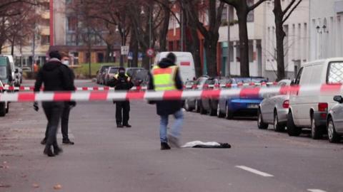 Officers (behind cordon) inspect items lying in middle of Berlin street