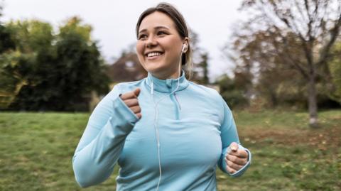 Woman running wearing headphones