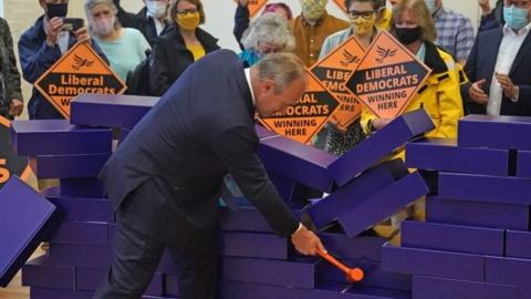 Ed Davey knocks over blue wall