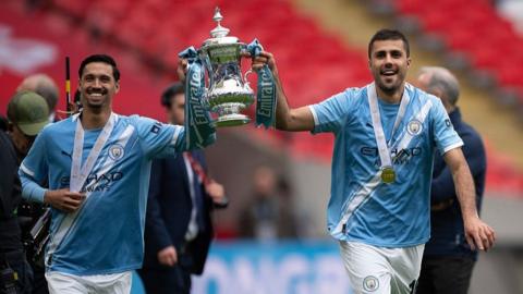 Tijjani Reinders and Rodri hold the FA Cup trophy