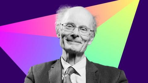 John Curtice smiling and looking down the camera with a multicolour triangle edited into the background