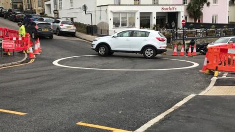 A car driving around the painted circle on Clevedon seafront