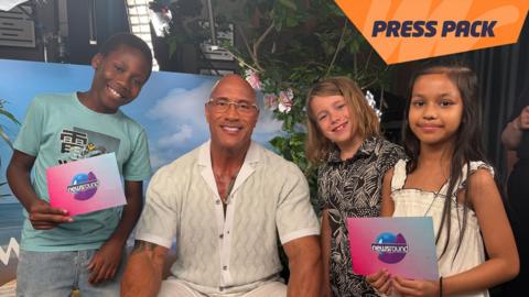 Dwayne Johnson sits in the middle of three children.
