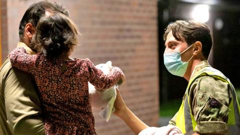 A RAF Brize Norton personnel hands out food, drinks, toys, and blankets during Operation Pitting on 26 August