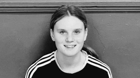 Black and white picture of a teenage girl with long hair in a pony tail