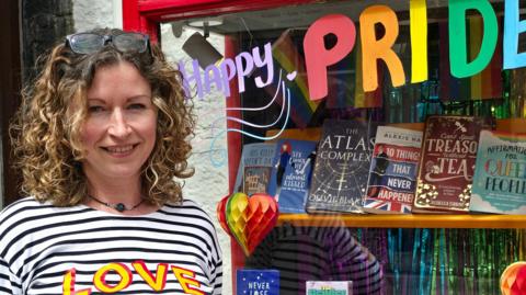 Sian Cowper standing in front of her shop window