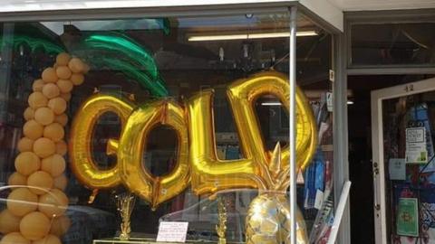 Shop front decorated with gold balloons