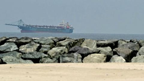  A ship is seen in the Persian Gulf off the coast of Sharjah the day after the failure of US-Iran peace talks on April 13, 2026. 