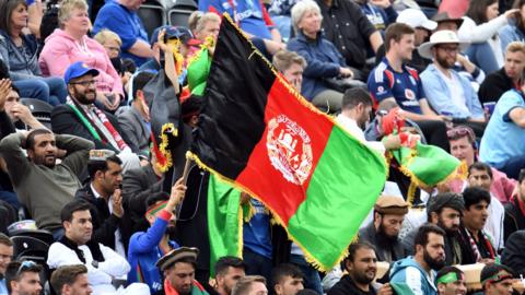 An Afghanistan cricket fan waves the country's flag at a 2019 World Cup match against England