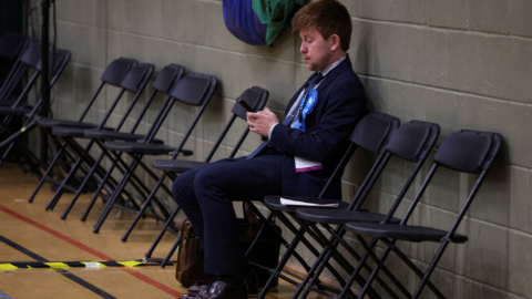 A Conservative Party supporter sits ahead of counting of votes, during the Blackpool South Parliamentary by-election,