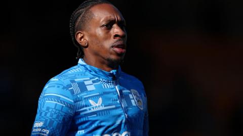 Mickel Miller warming up before a Huddersfield Town match