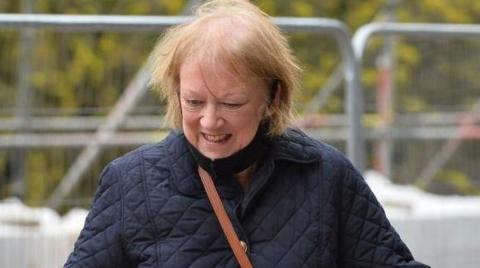 Fair-haired Ann Dunlop entering court, with a back/dark blue jacket on. Her head is facing down and not facing the camera