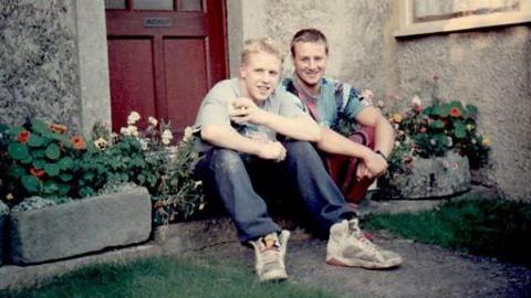 Rob Russell and his brother Roddy sit on the steps of their home in Gloucestershire around 1990